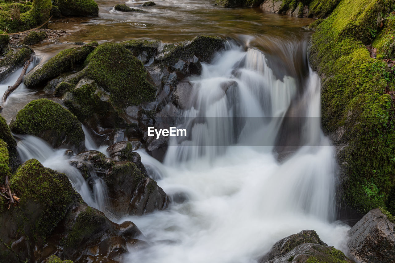 Long exposure of a waterfall flowing over rocks at watersmeet in exmoor national park