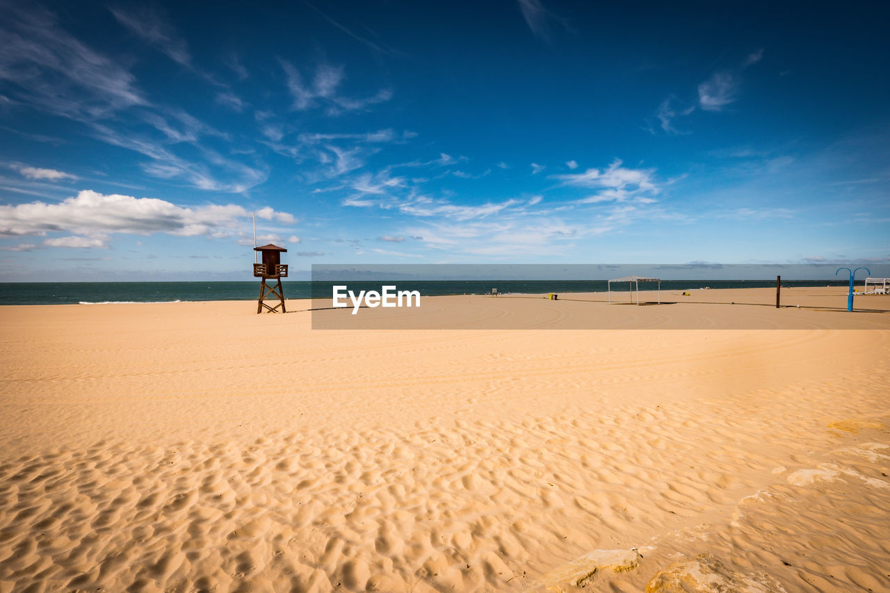 MAN ON BEACH AGAINST SKY