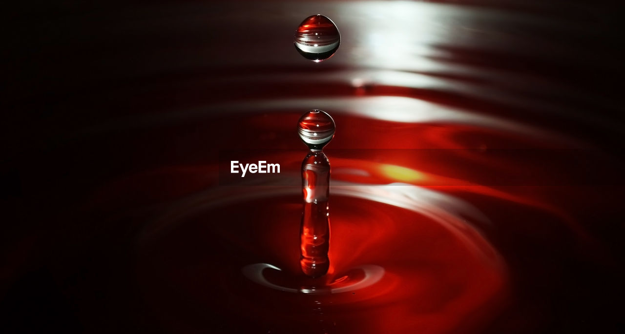 CLOSE-UP OF WATER DROP ON RED BALL