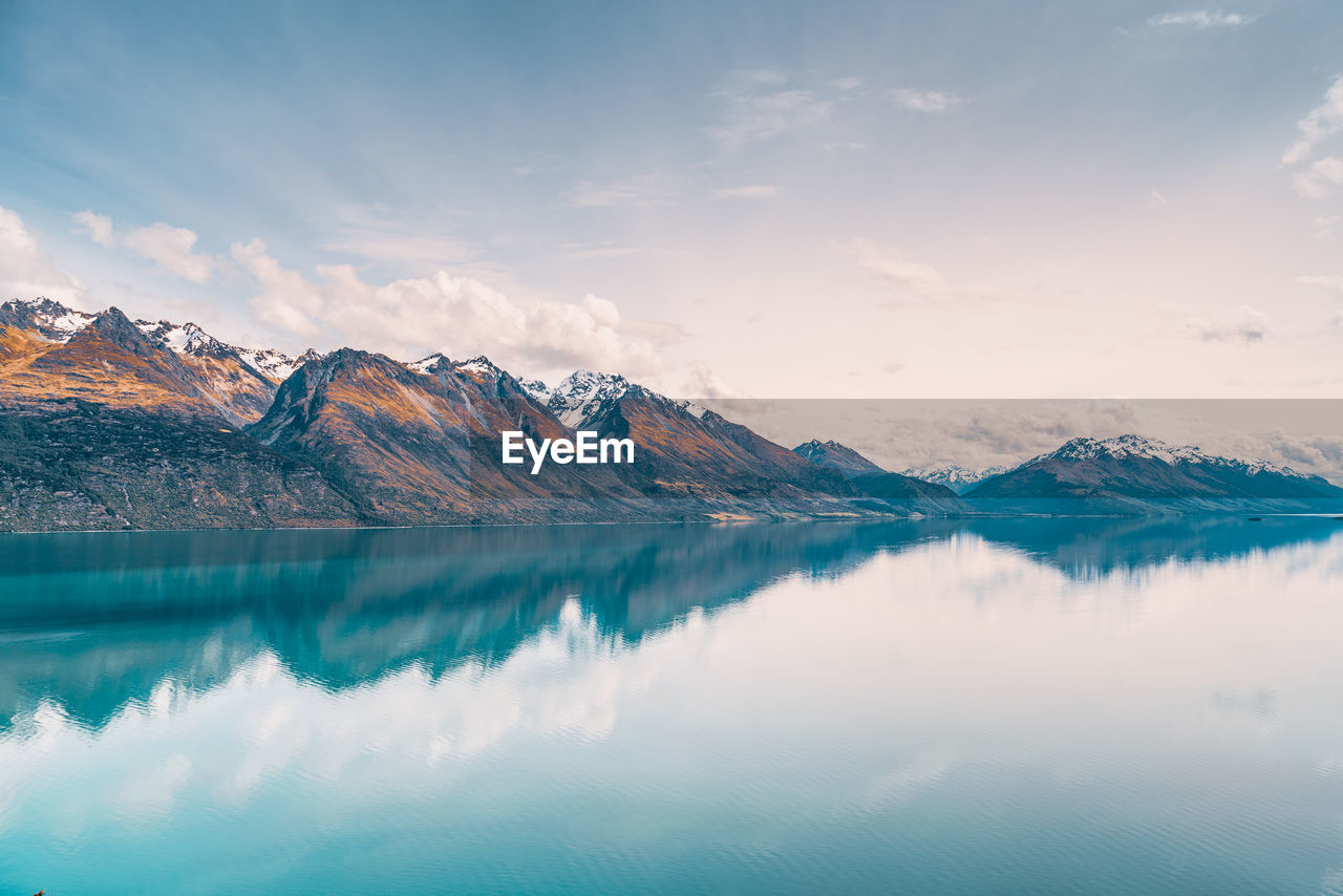 Scenic view of lake and snowcapped mountains against sky