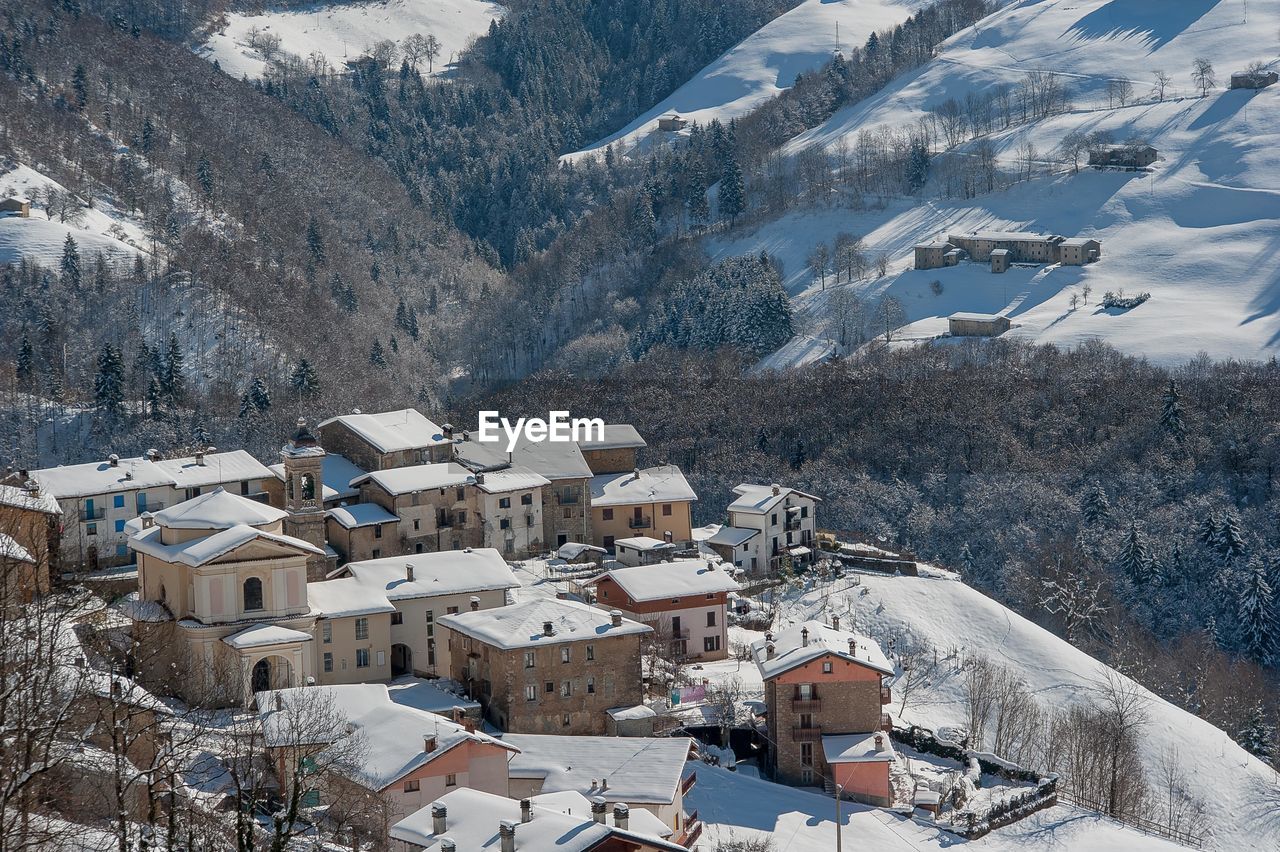 High angle view of townscape and snowcapped mountains