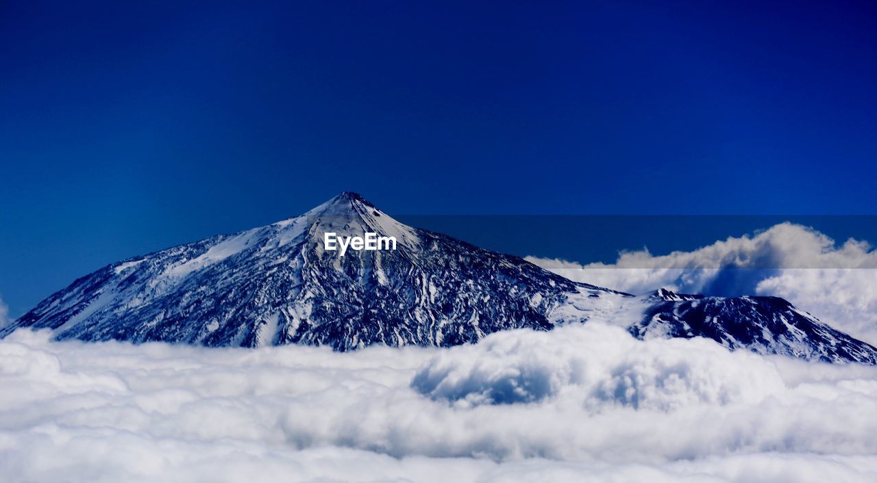 Scenic view of snowcapped mountains against clear blue sky