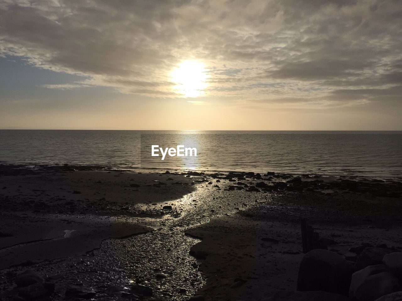 SCENIC VIEW OF BEACH AGAINST SKY AT SUNSET