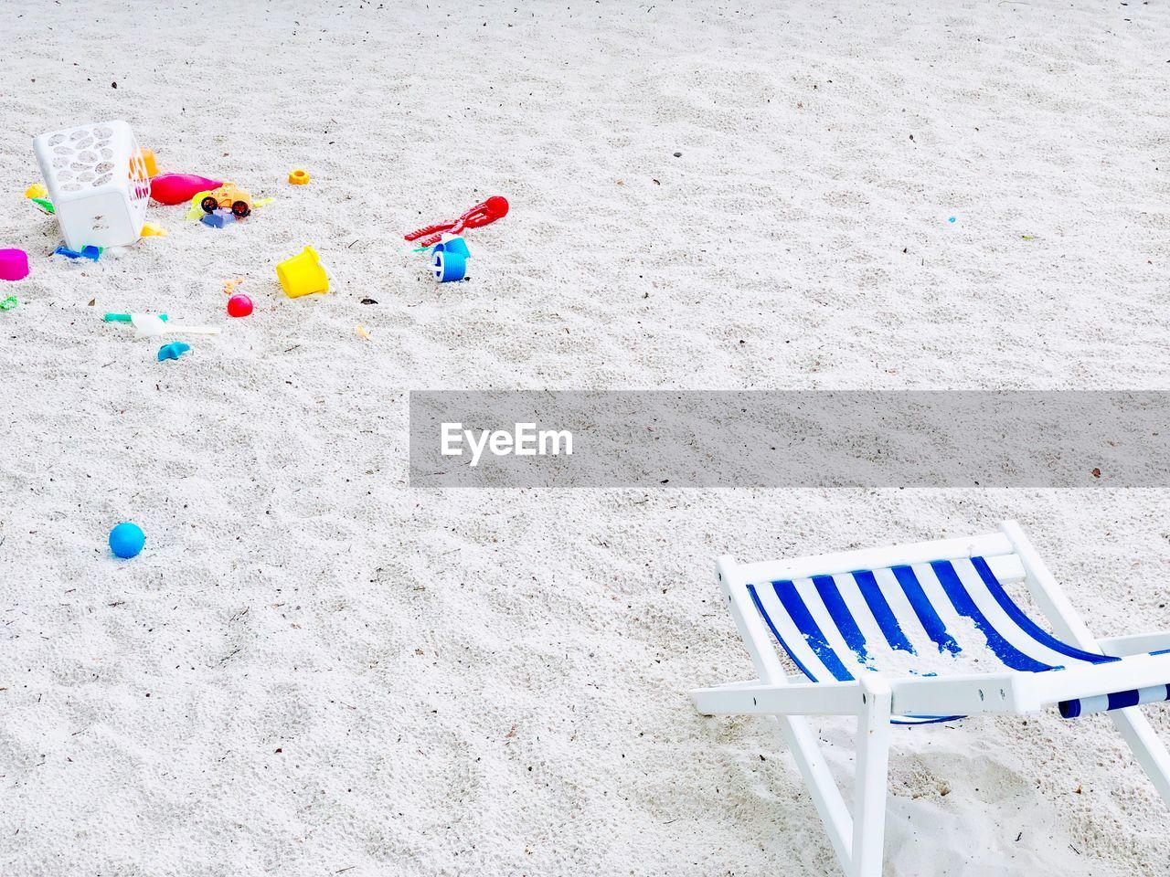 HIGH ANGLE VIEW OF TOYS ON SAND