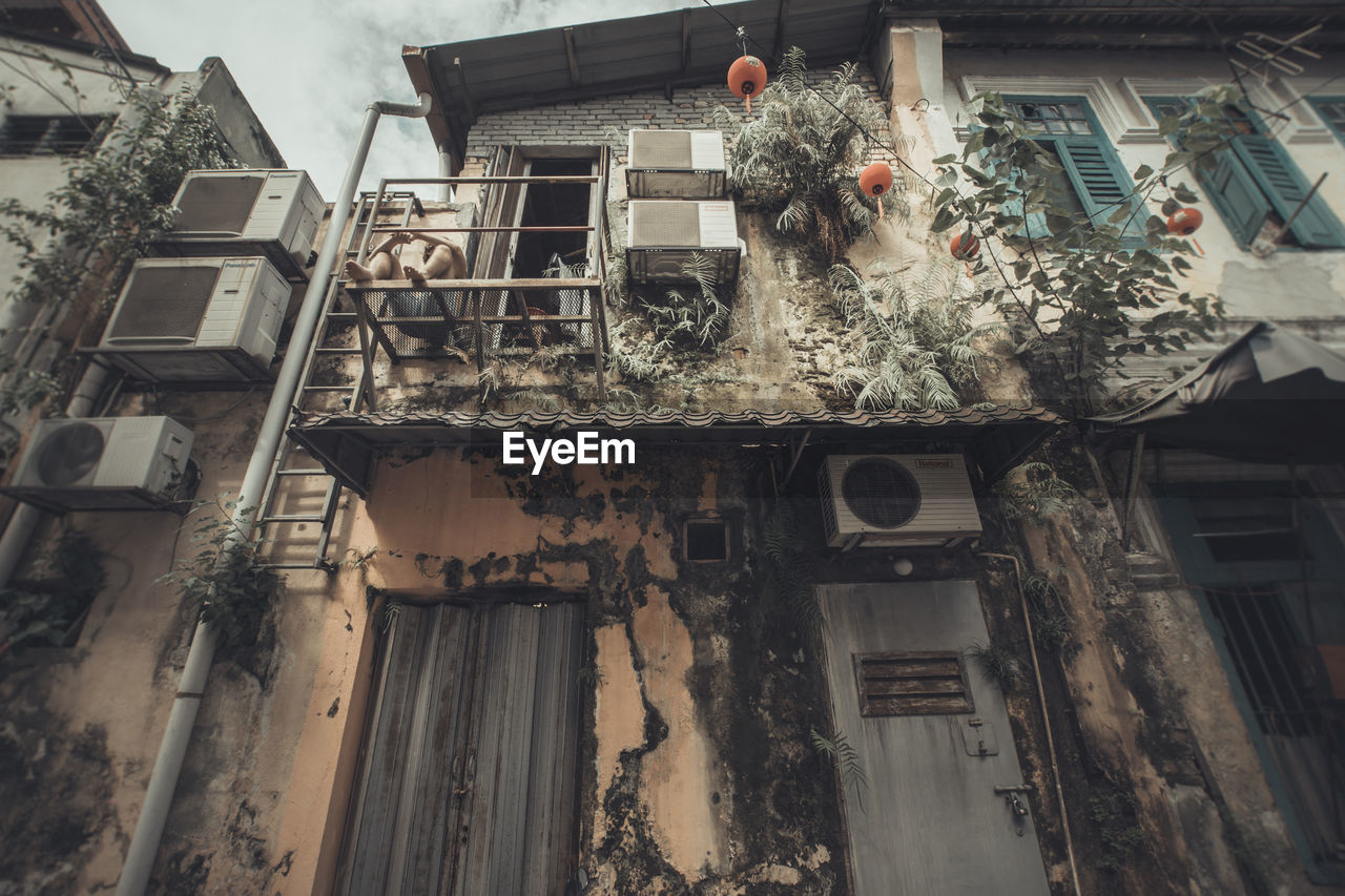 Low angle view of man sitting in balcony