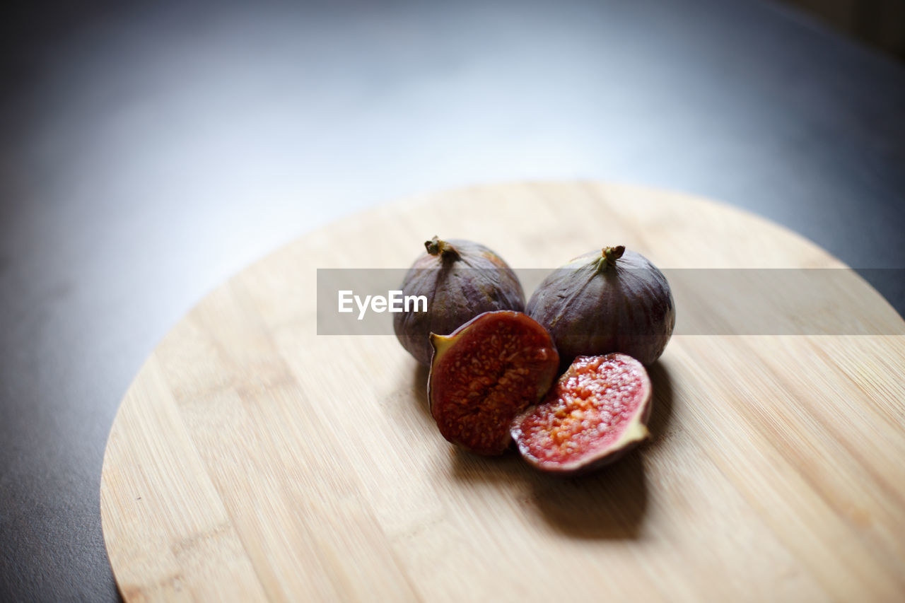 Close-up of figs on cutting board over table