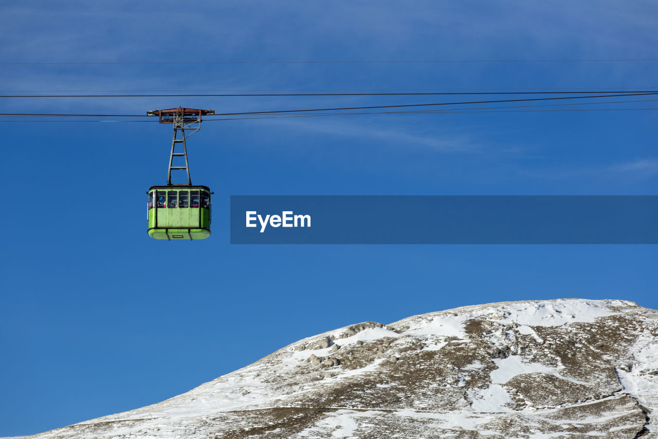 OVERHEAD CABLE CAR AGAINST BLUE SKY