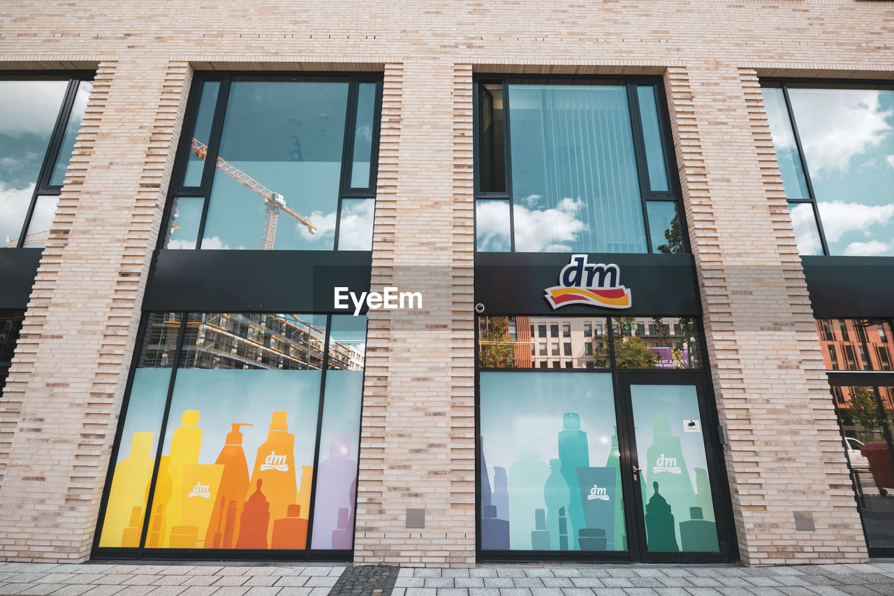 LOW ANGLE VIEW OF GLASS BUILDING WITH WINDOWS