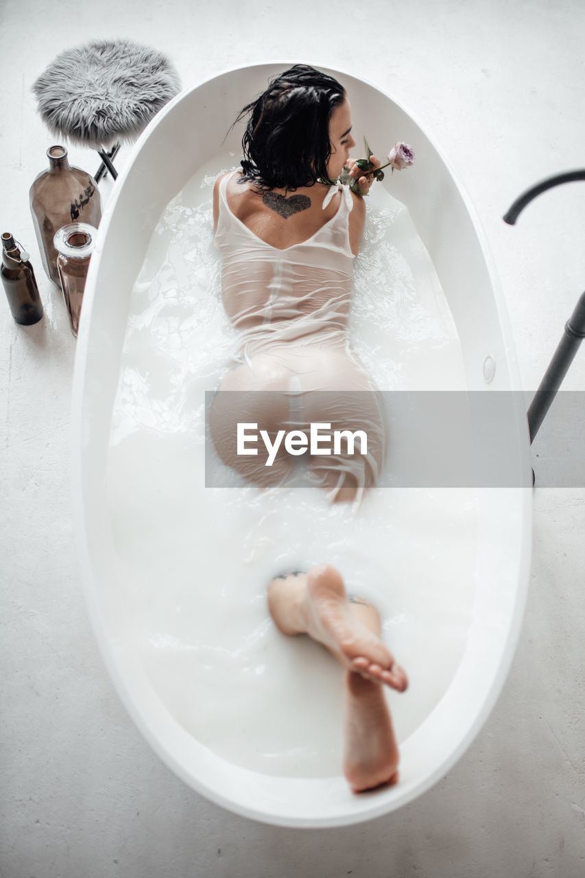 High angle view of woman lying in bathtub