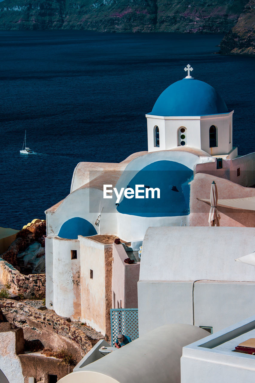 Greek white church with blue dome in santorini.