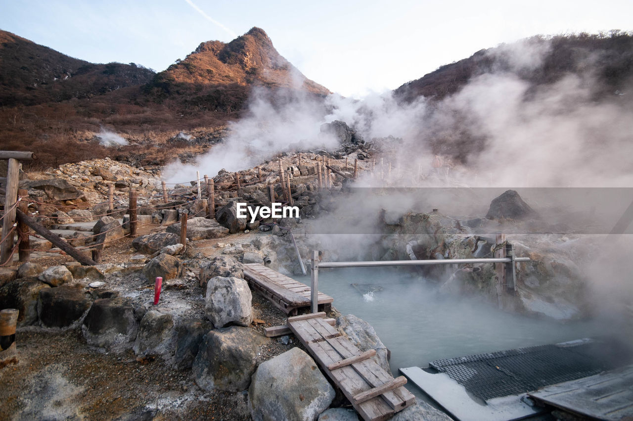 Smoke emitting from hot springs by mountains