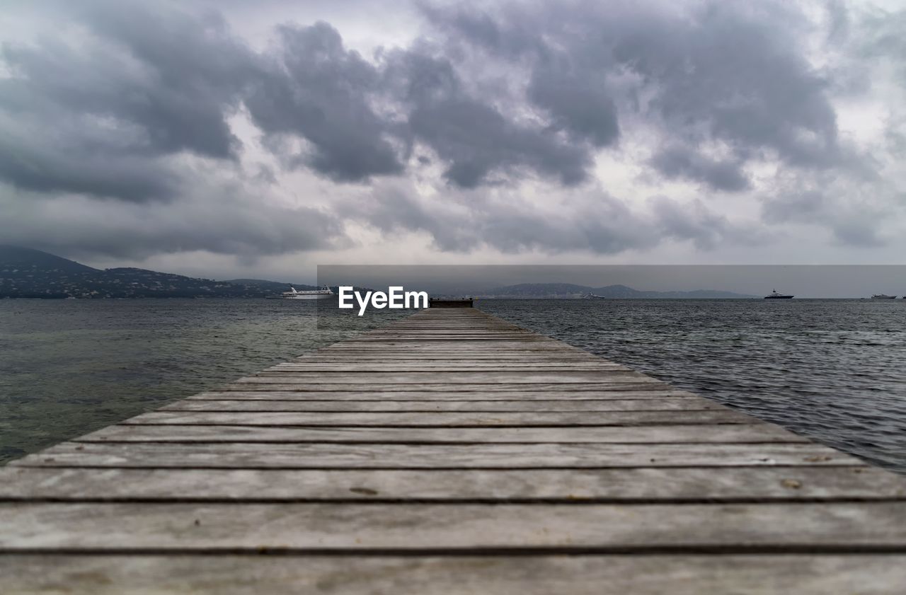 Surface level of pier over sea against sky