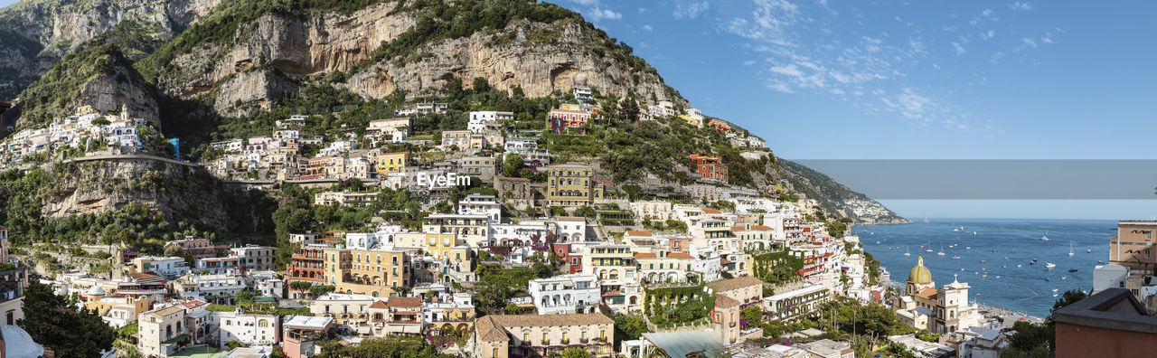 AERIAL VIEW OF TOWNSCAPE BY SEA AGAINST SKY