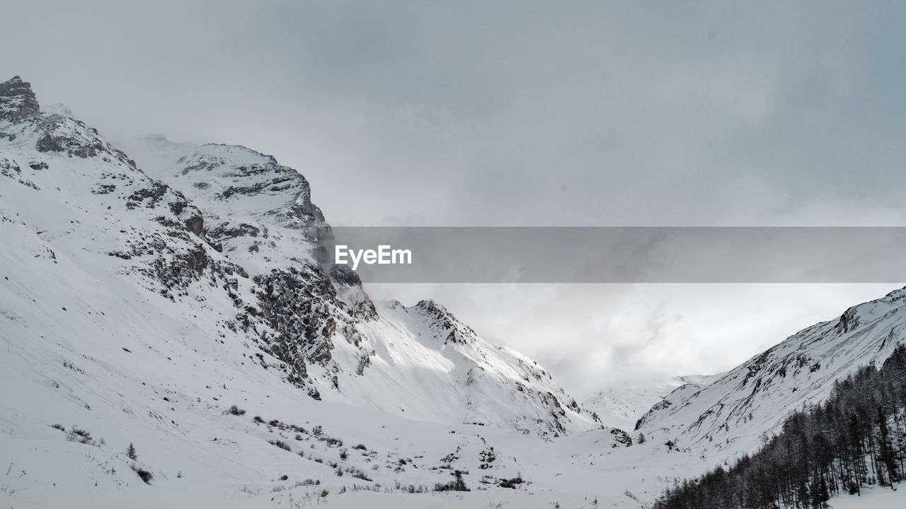 Scenic view of snow covered mountains against sky