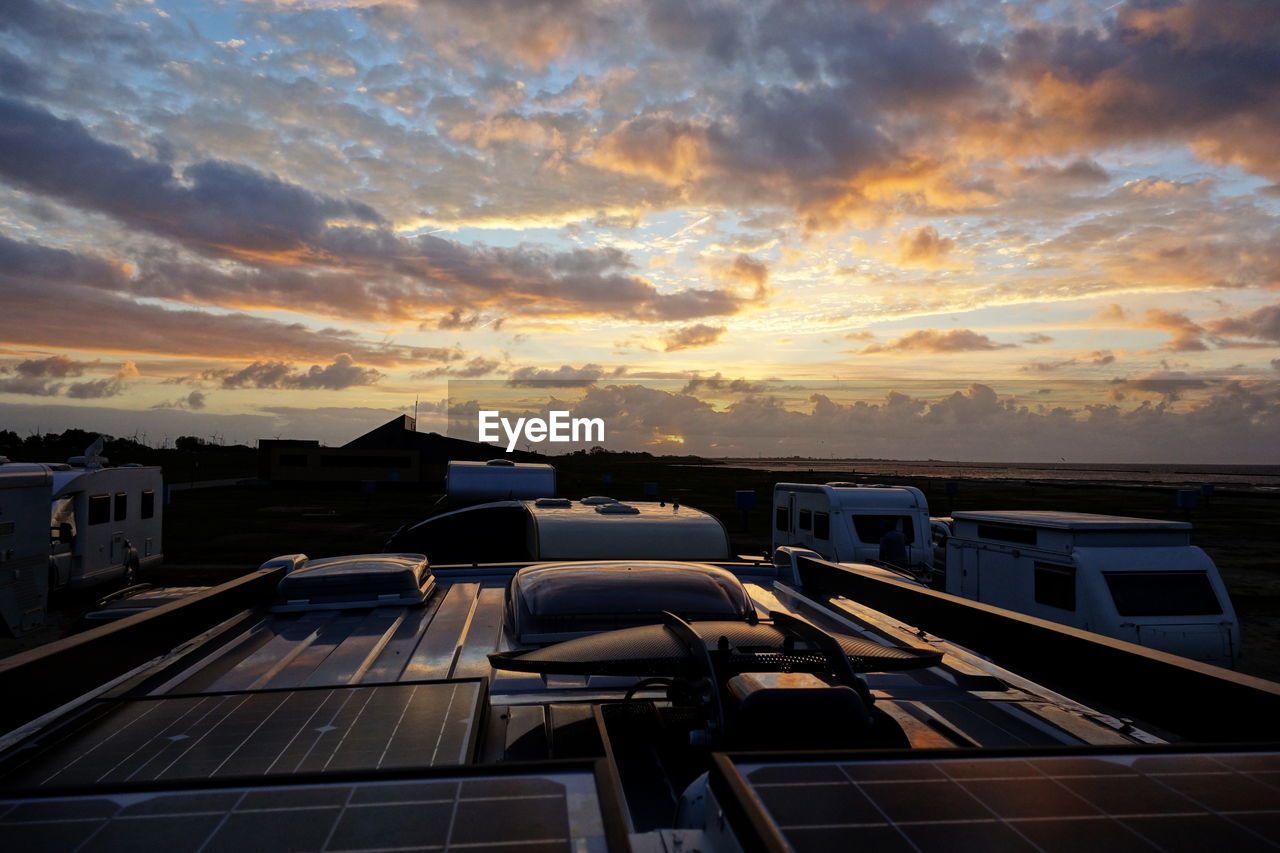 Motorhome roof on camping site against sky during sunset