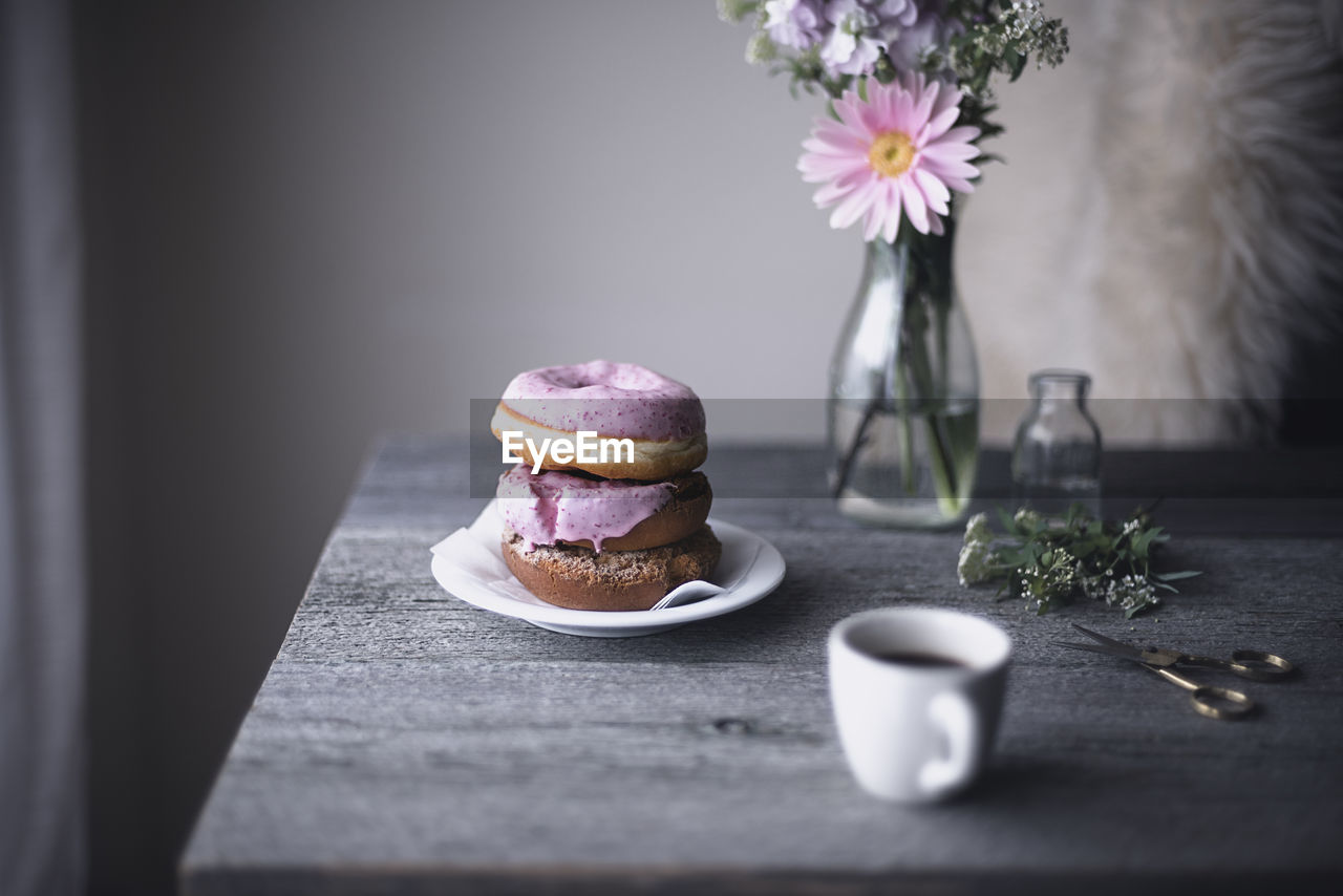 Donuts and coffee cup on table at home