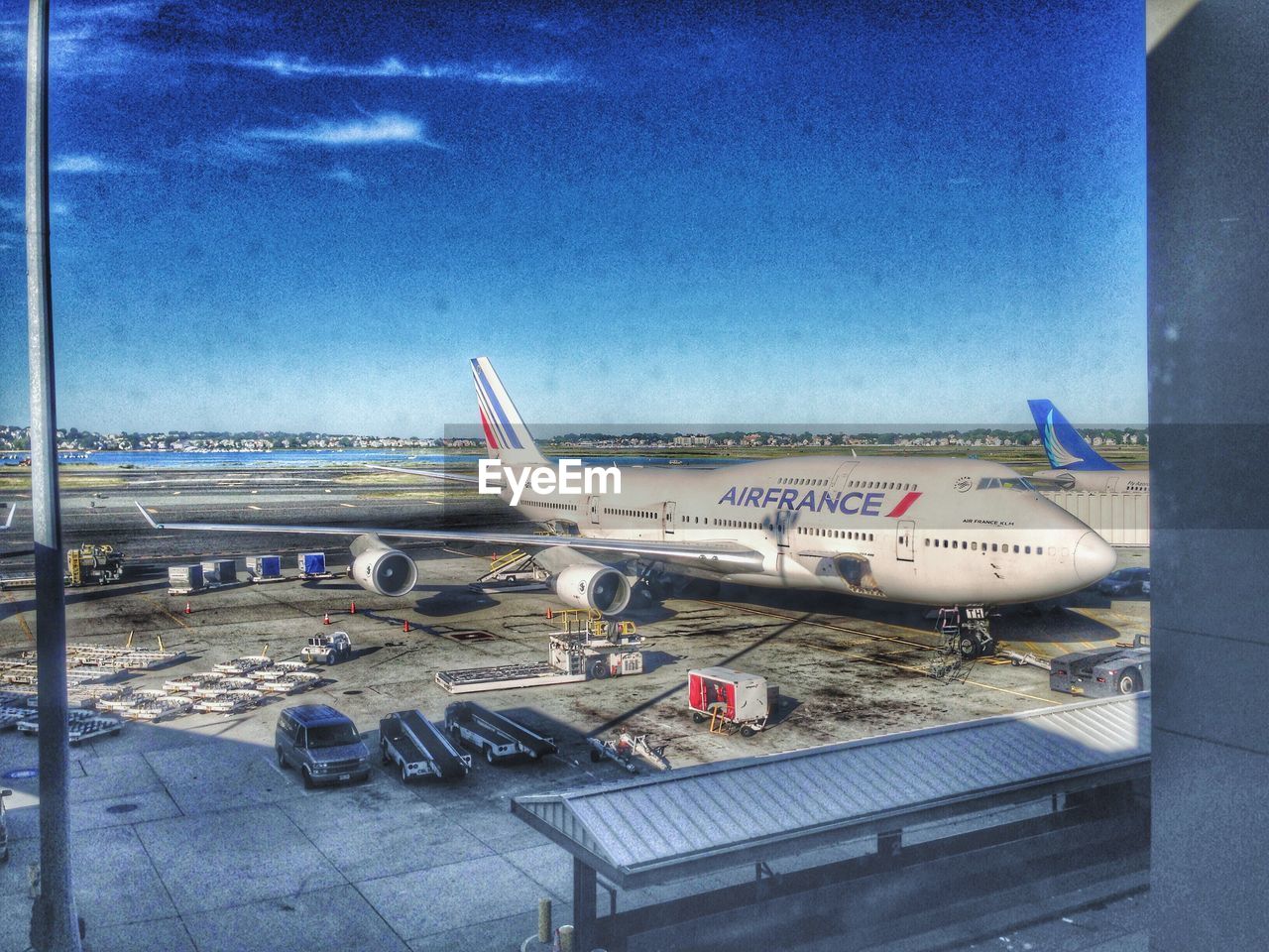 VIEW OF AIRPLANE ON AIRPORT RUNWAY AGAINST SKY