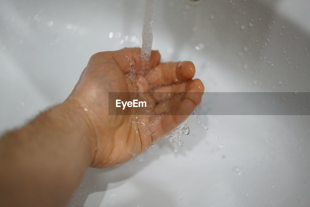 CROPPED IMAGE OF PERSON HAND IN WATER