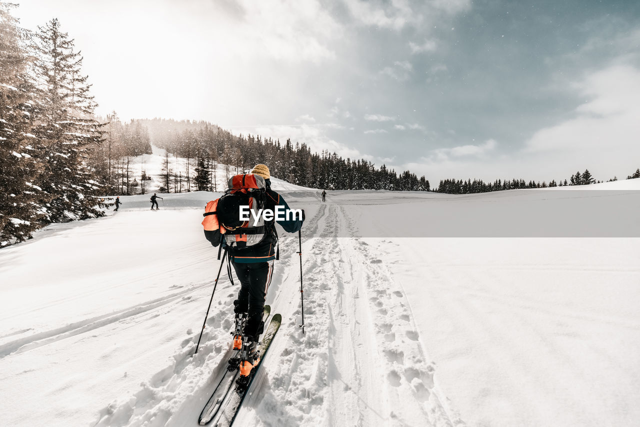 Active senior man skiing on snow covered land during vacation