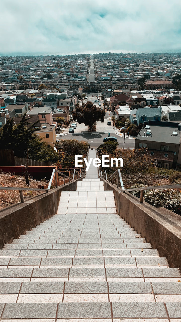 High angle view of staircase leading towards town against sky