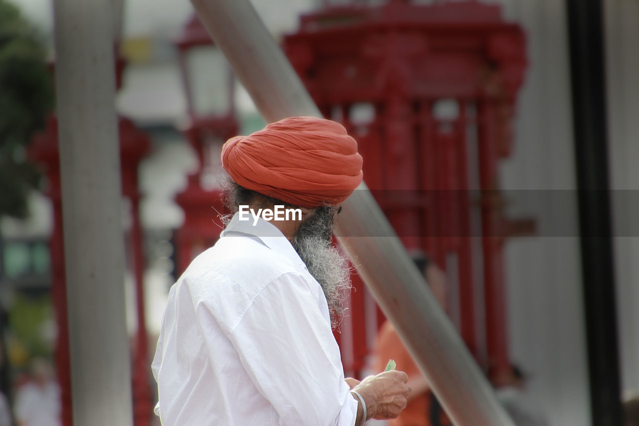 Side view of man wearing turban while standing outdoors