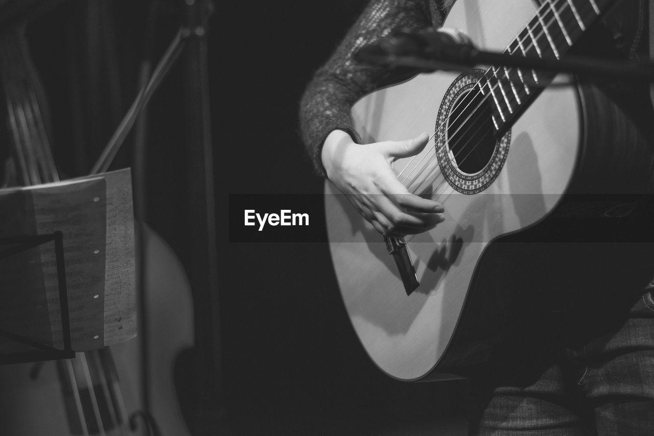 Midsection of guitarist performing on stage