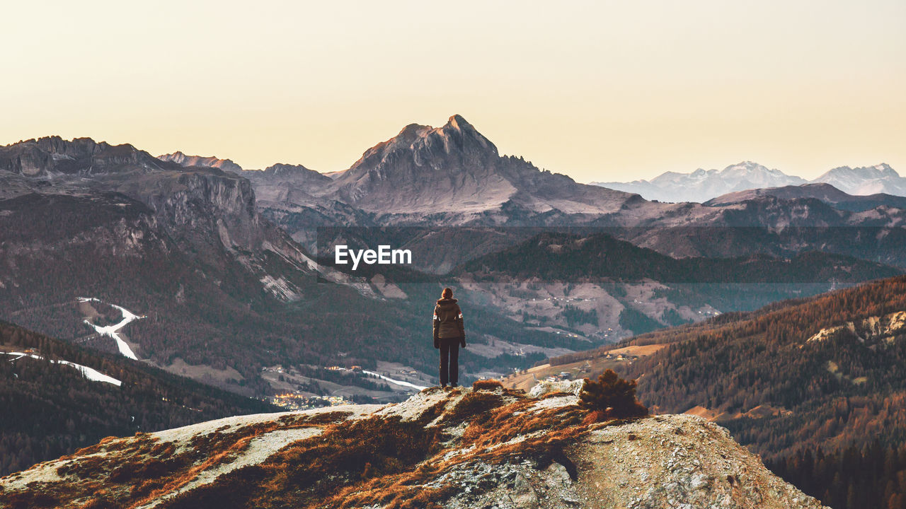 Rear view of person standing on cliff at dolomites