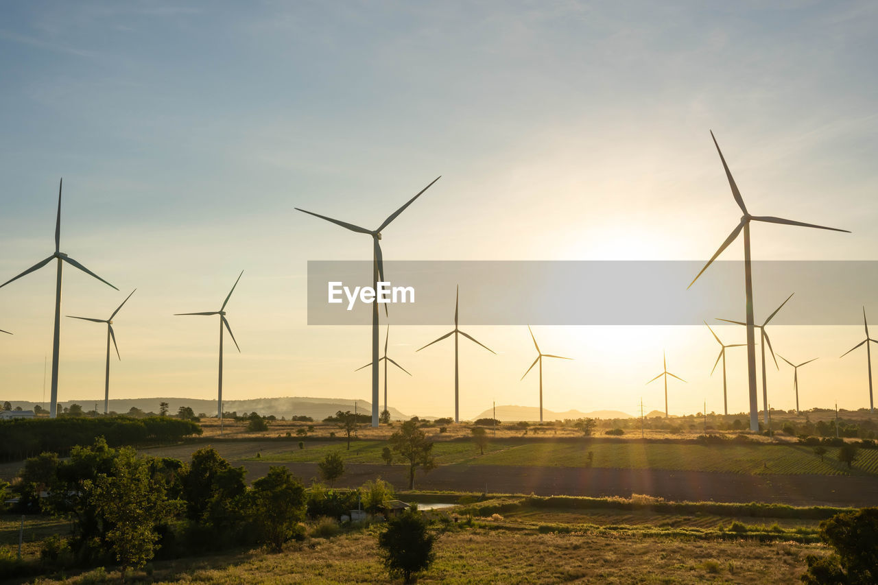 WIND TURBINES ON FIELD AGAINST SKY