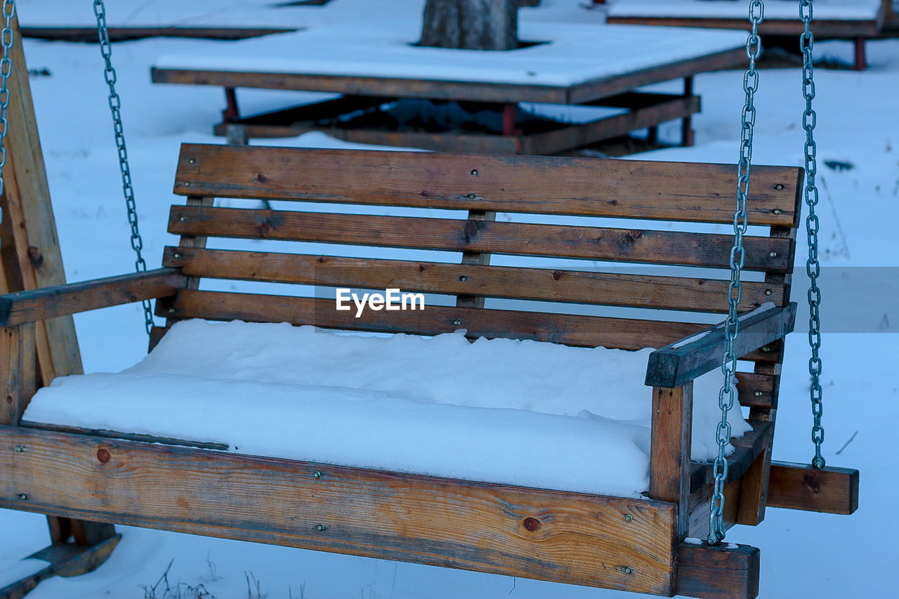 HIGH ANGLE VIEW OF EMPTY BENCH ON SNOW