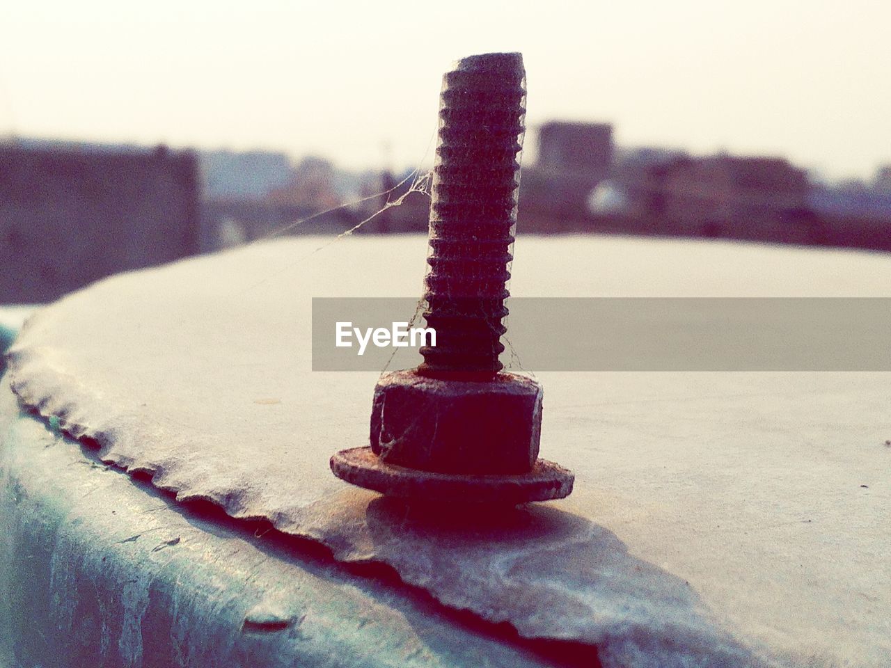 Close-up of rusty nail against sky