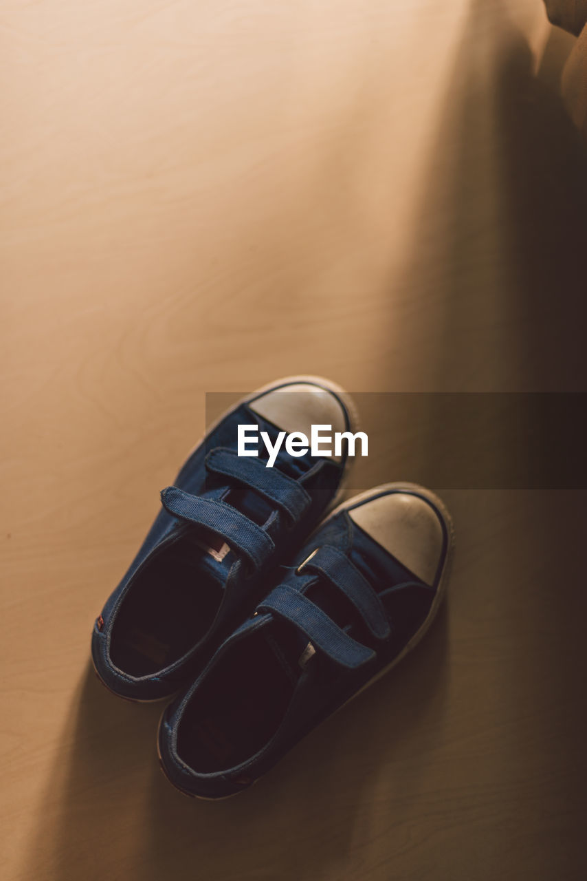 HIGH ANGLE VIEW OF SHOES ON WOODEN TABLE
