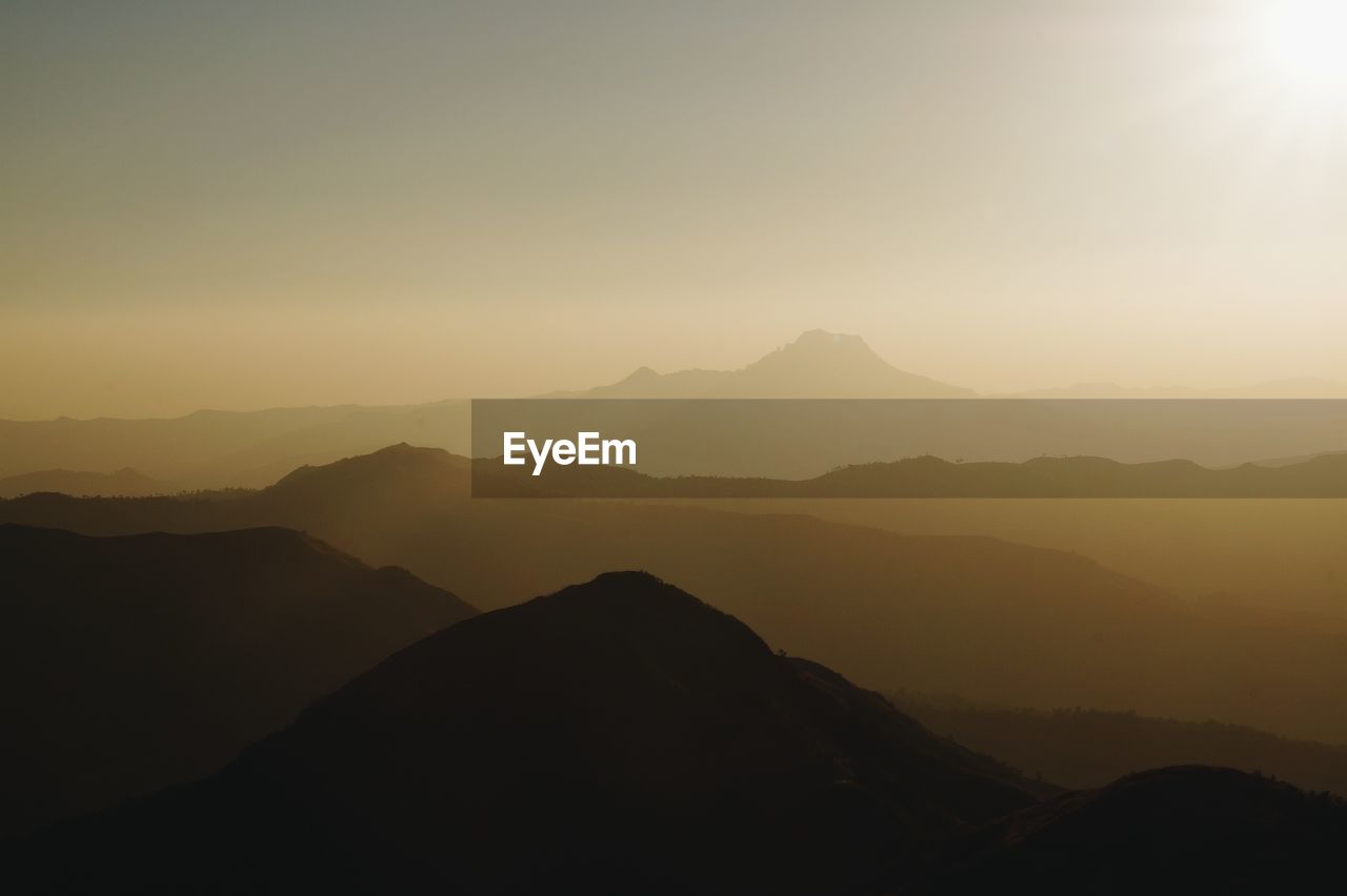 Scenic view of silhouette mountains against sky during sunset