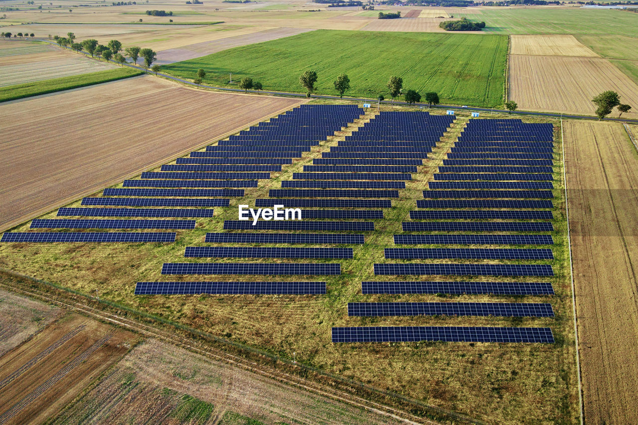 Solar energy production using solar battery panels in field, view from above