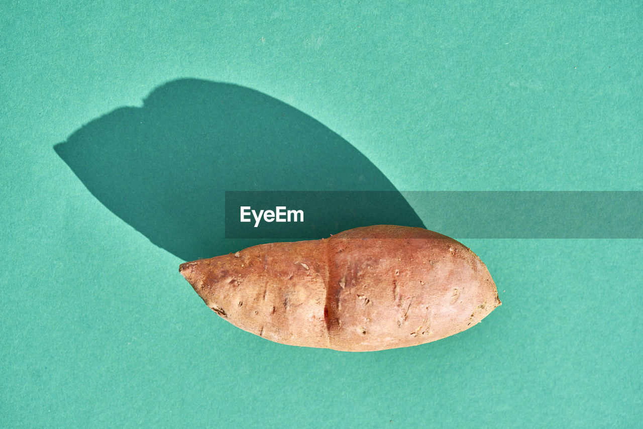 Directly above shot of sweet potato against turquoise background