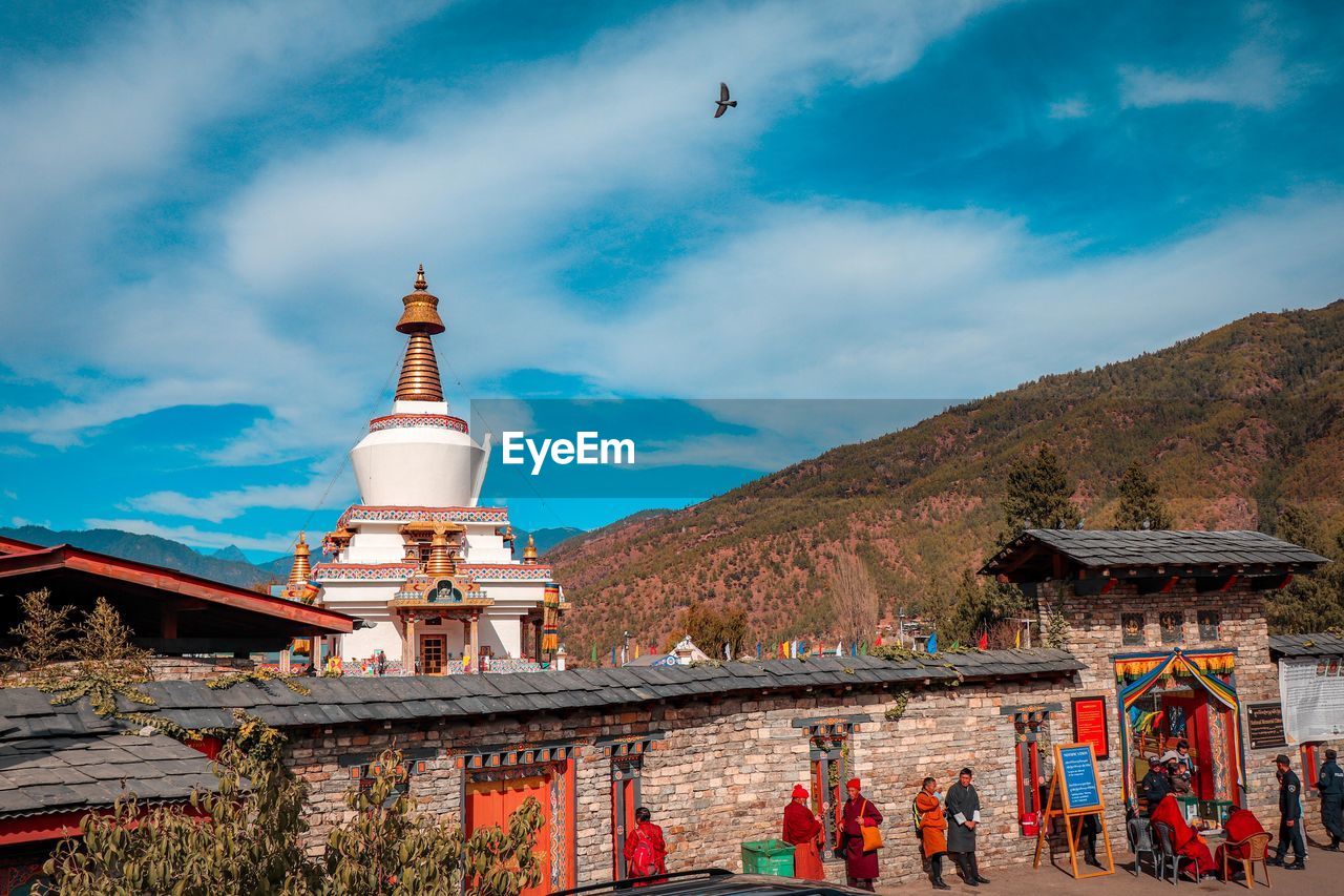 VIEW OF BUILDING AND MOUNTAINS AGAINST SKY