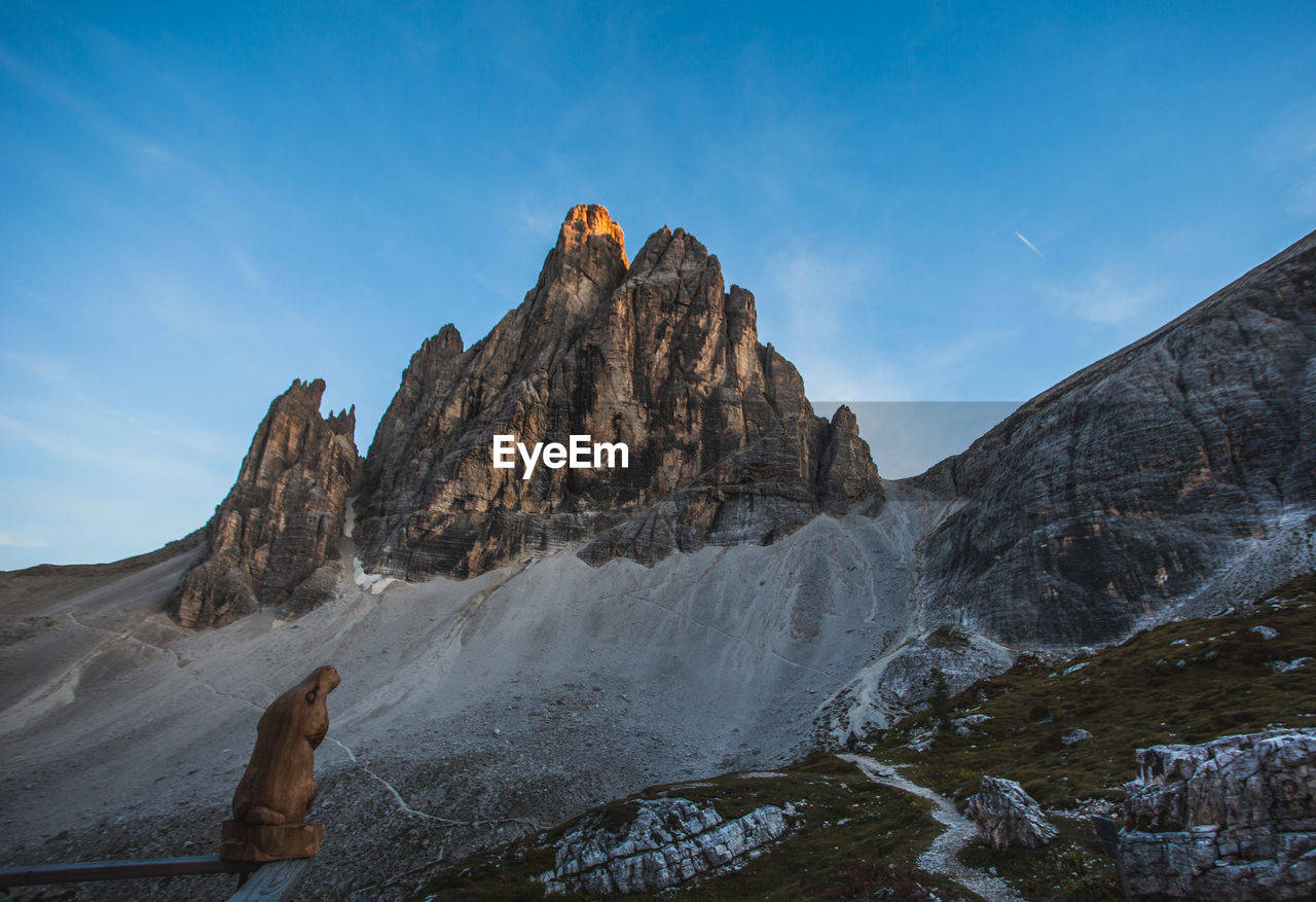 Wooden sculpture depicting a marmot in front of a magnificent dolomitic peak, south tyrol, italy