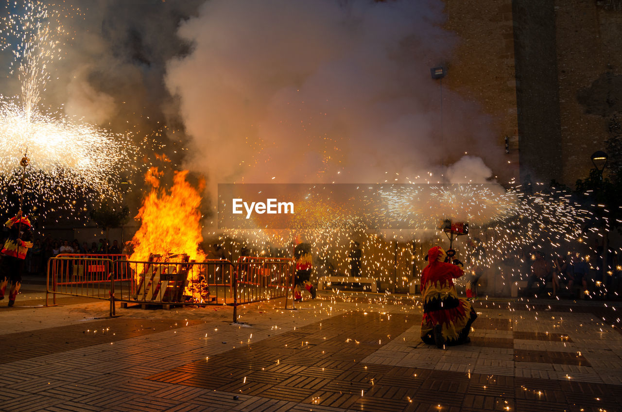 burning, fire, night, fireworks, flame, heat, celebration, group of people, bonfire, nature, motion, smoke, event, exploding, sign, street, city, men, accidents and disasters, tradition, arts culture and entertainment, architecture, outdoors, explosion, occupation, warning sign, firefighter