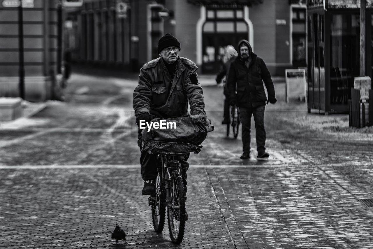 People walking on wet street during rainy season