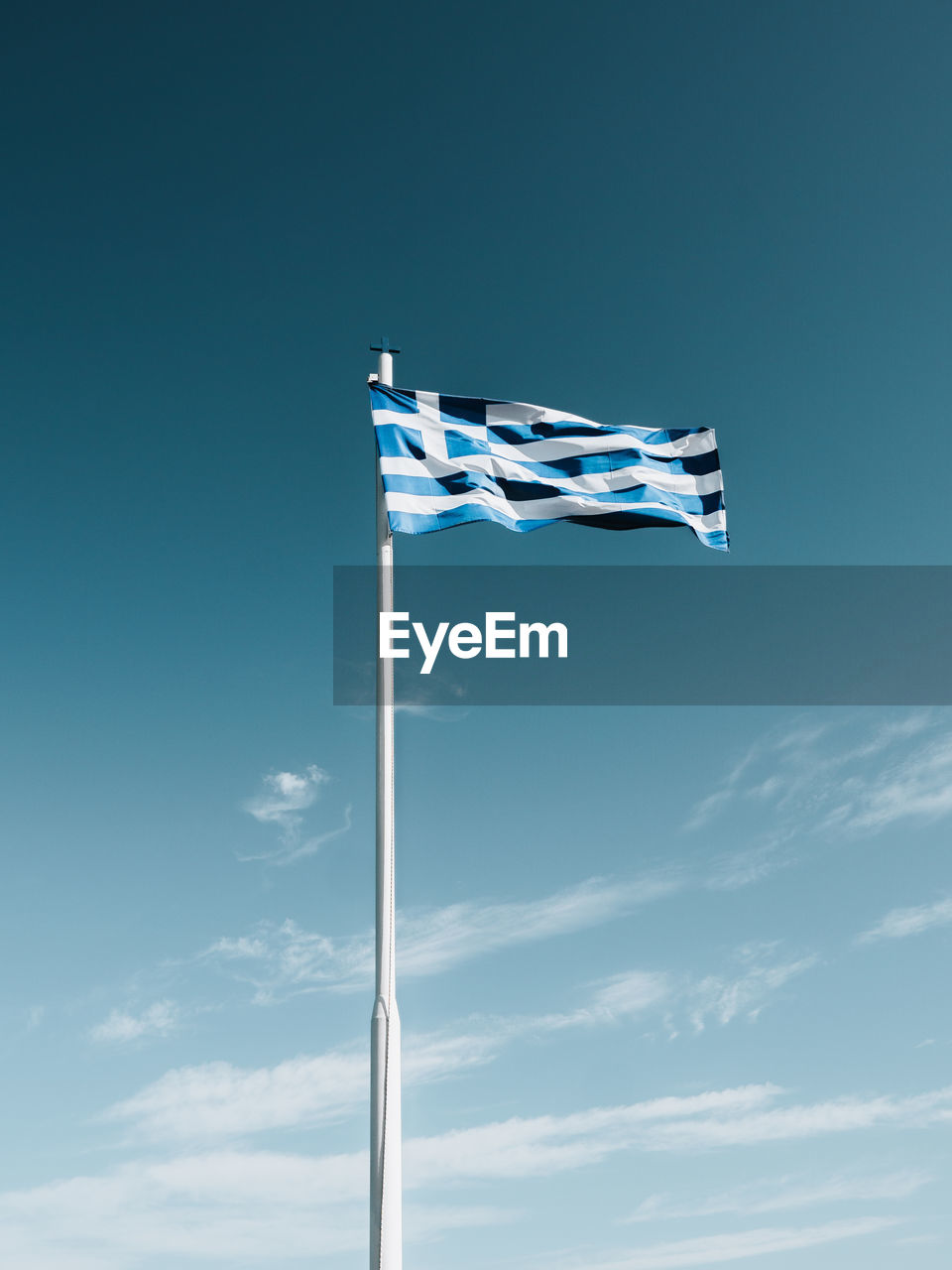 Low angle view of greek flag against blue sky