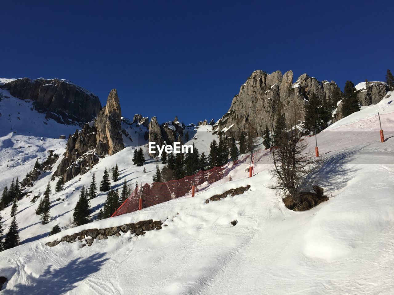 Panoramic view of snowcapped mountains against clear blue sky