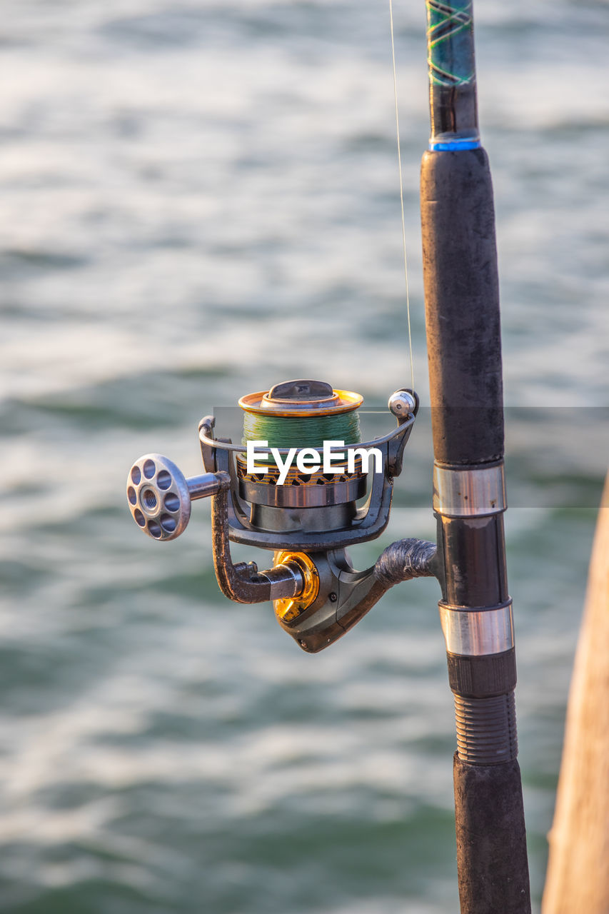 The crank of a fishing rod with reel foot, reel seat, spool, coiled line and spool brake