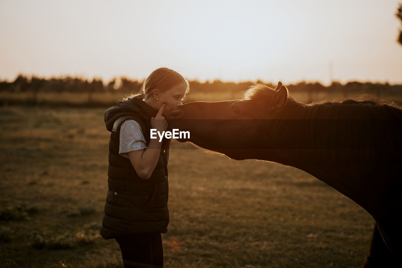 Girl with pony on meadow