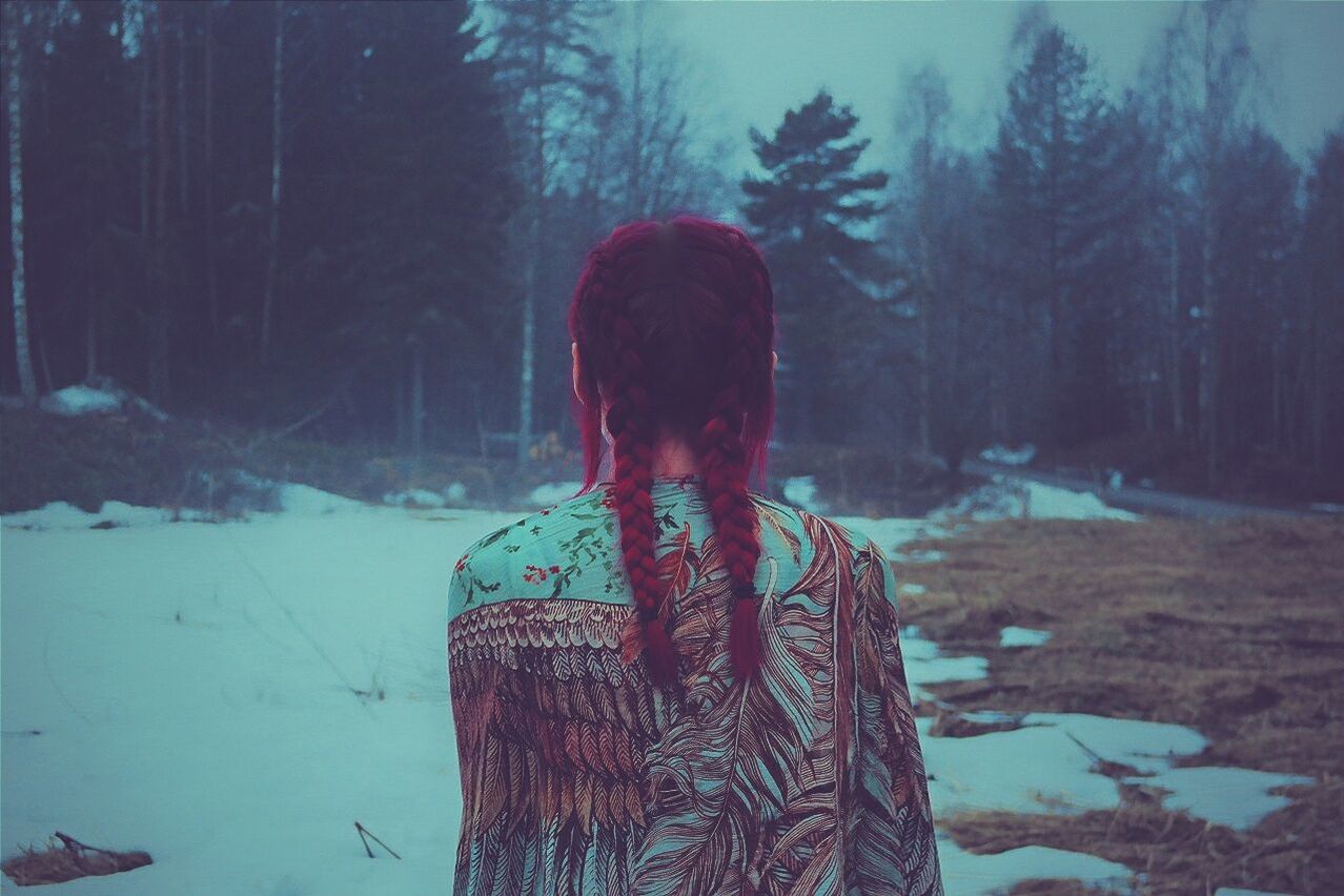 Rear view of woman standing on field during winter