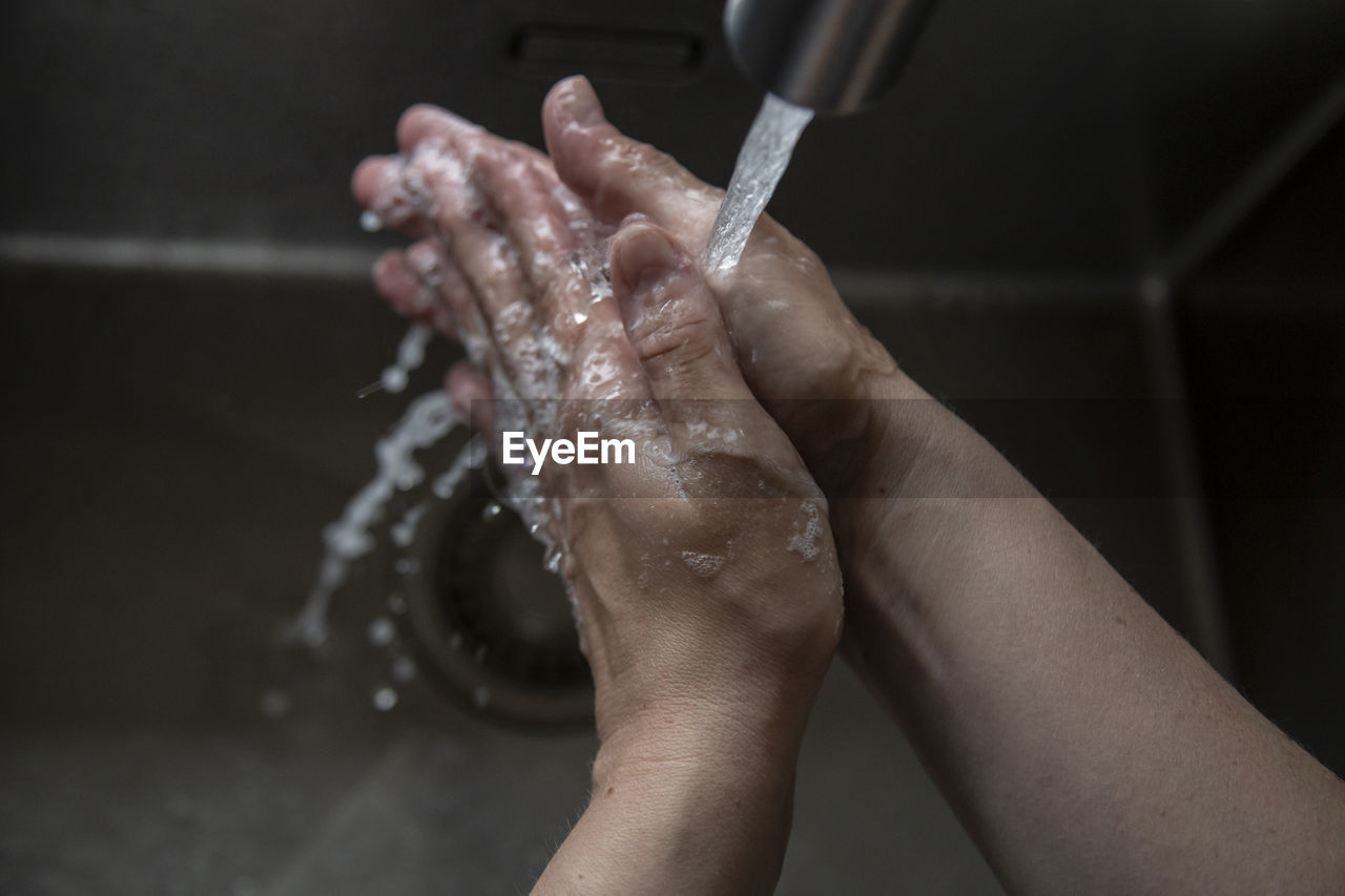 Close up of someone rinsing hands in the sink