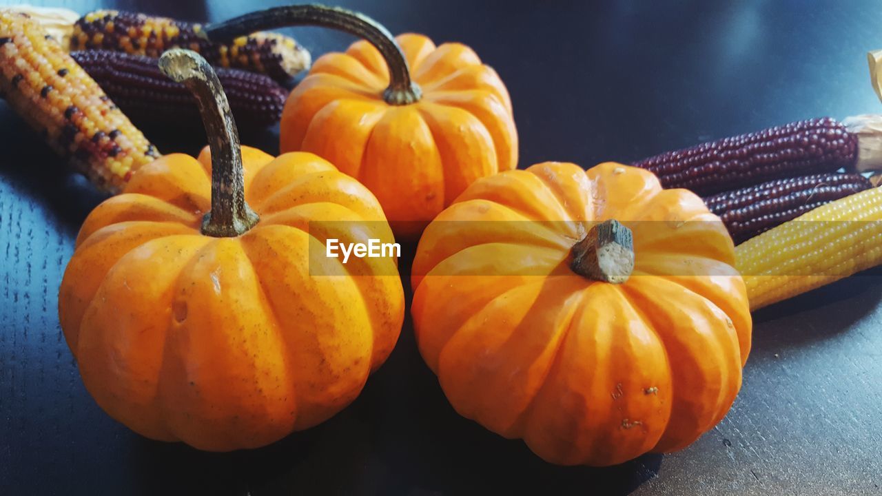 High angle view of pumpkins and corns on table