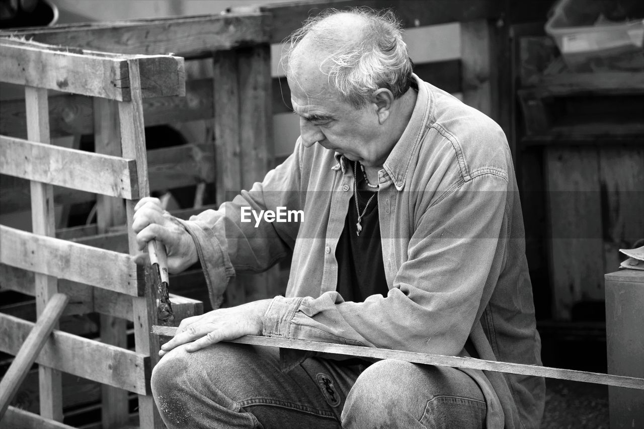 Man using pliers to repair wood 