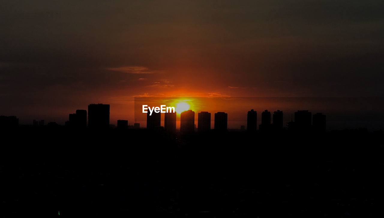 Silhouette buildings against sky during sunset