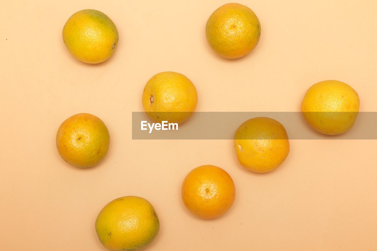 Directly above shot of orange fruits on colored background