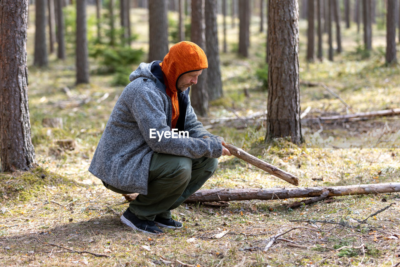 rear view of woman wearing hat standing in forest