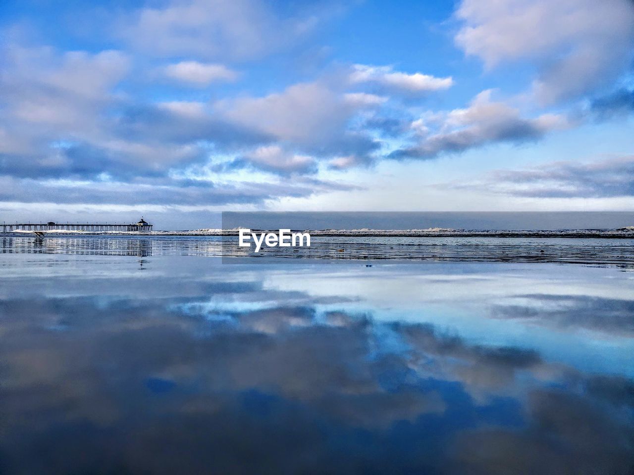 SCENIC VIEW OF BEACH AGAINST CLOUDY SKY